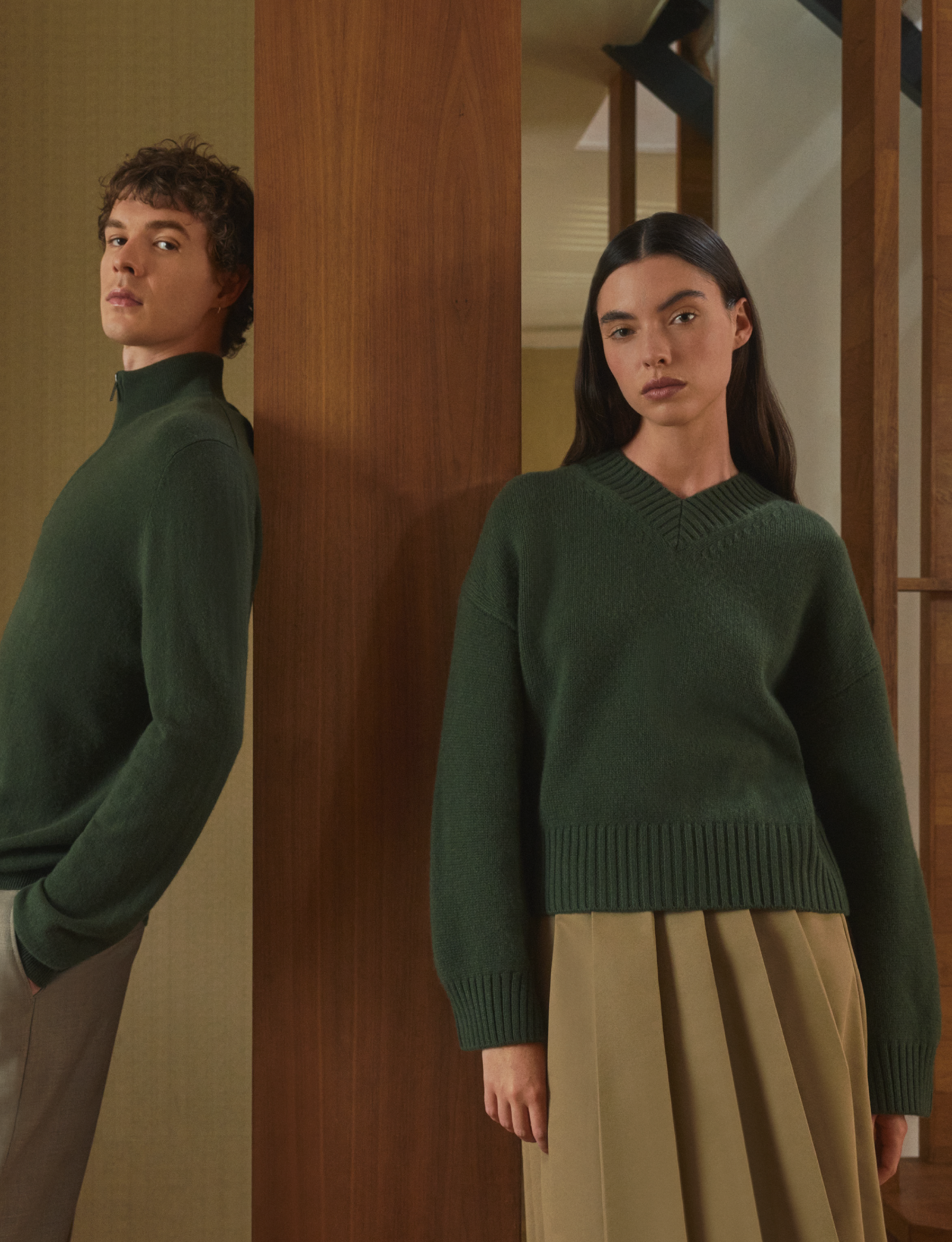 Man wearing Pringle of Scotland Cashmere Qtr Zip and women wearing chunky cashmere v neck, both in evergreen