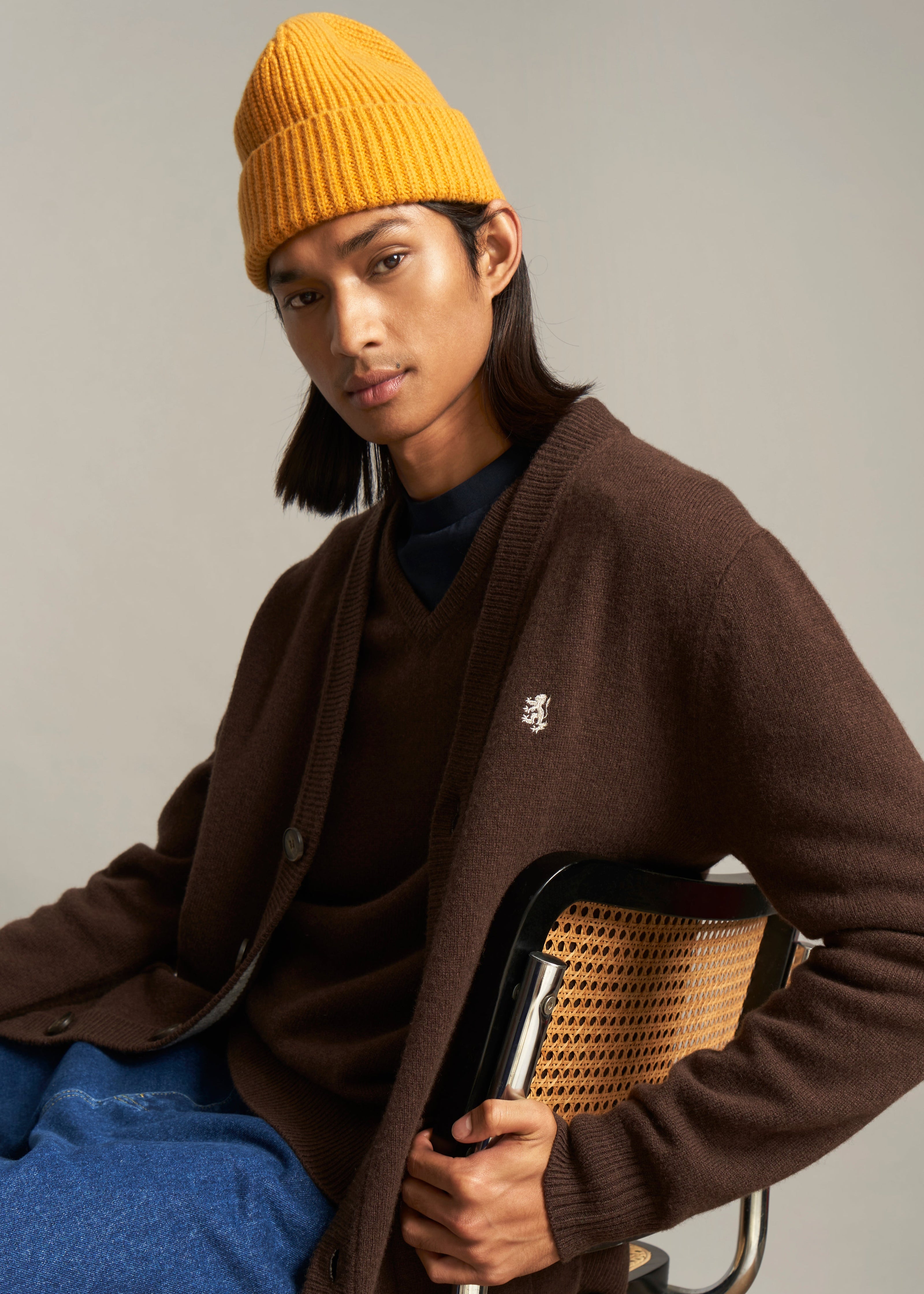 Pringle of Scotland Men's V Neck Lambswool Cardigan In Dark Umber on seated model