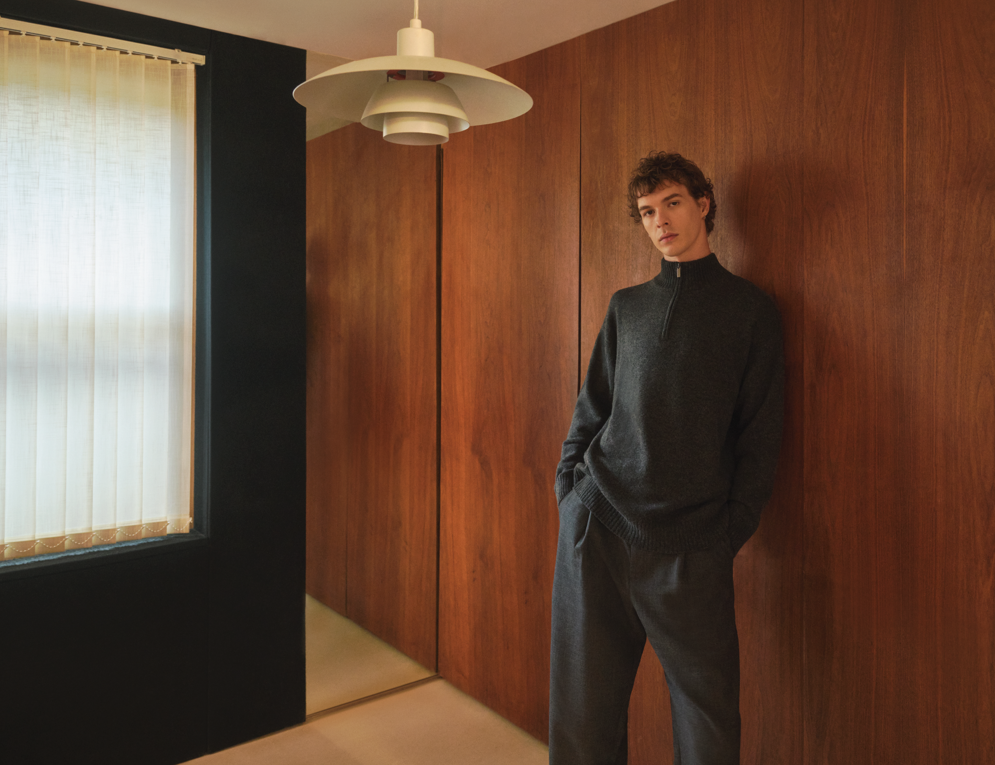 Pringle of Scotland Image With Male Model Wearing Zip Neck Cashmere Jumper in Charcoal Linking to Brand Story