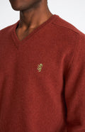 Pringle V Neck Lion Lambswool Jumper In Red Rust & Mineral Green showing embroidery
