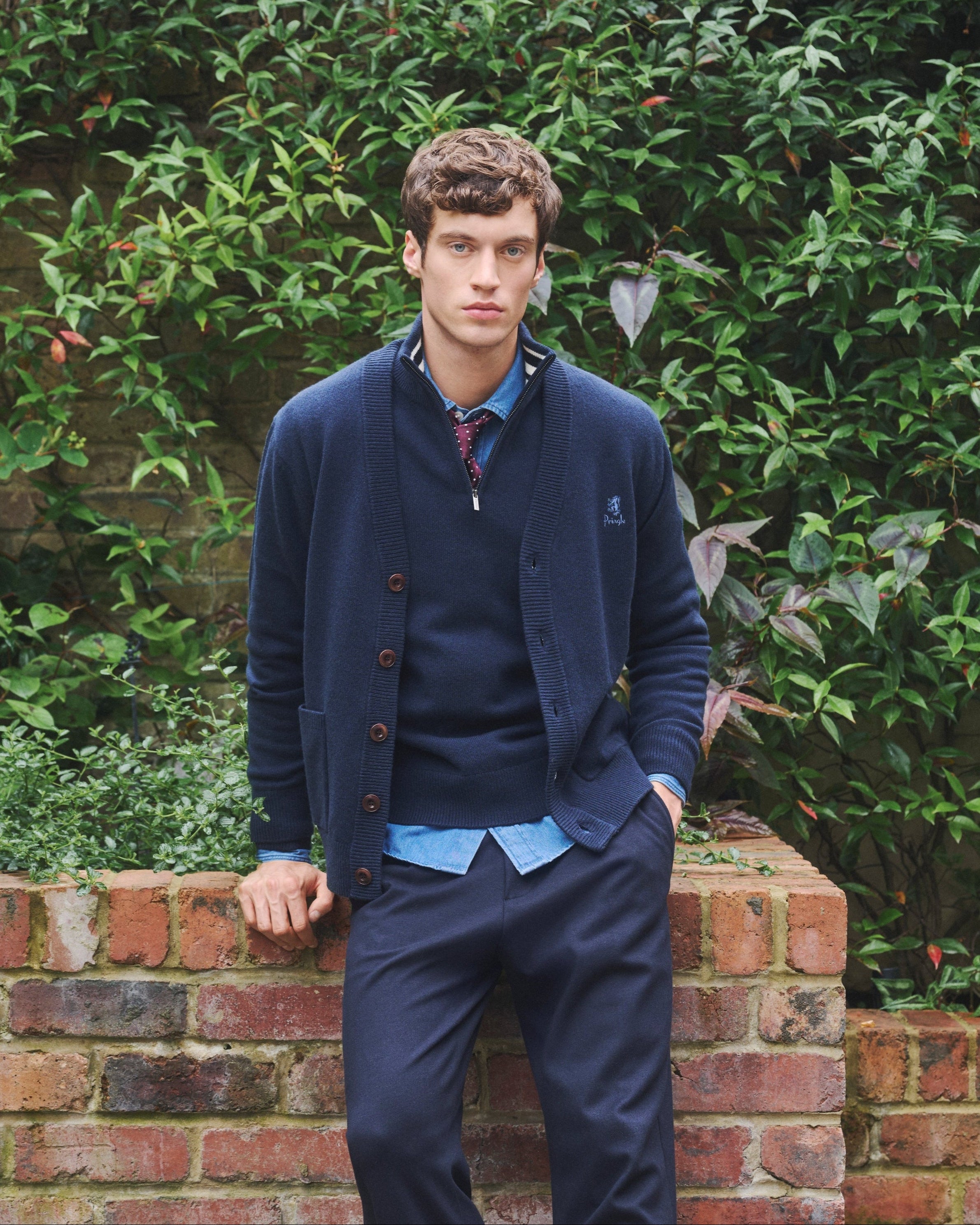 Man wearing supersoff lambswool collection from Pringle of Scotland standing in the garden