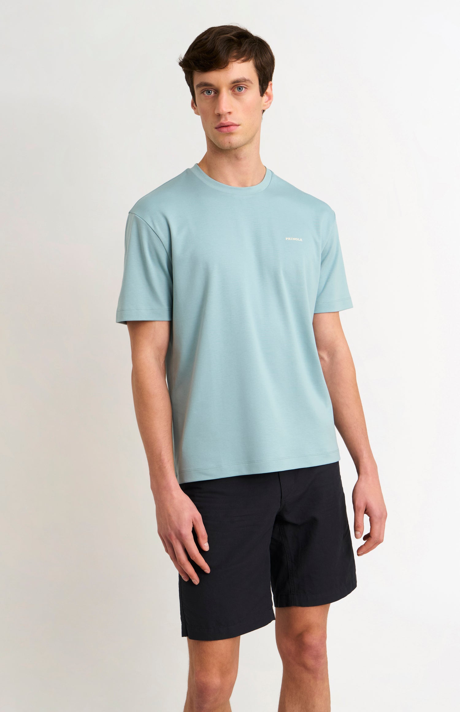 Man wearing a blue t-shirt and black shorts on a white background