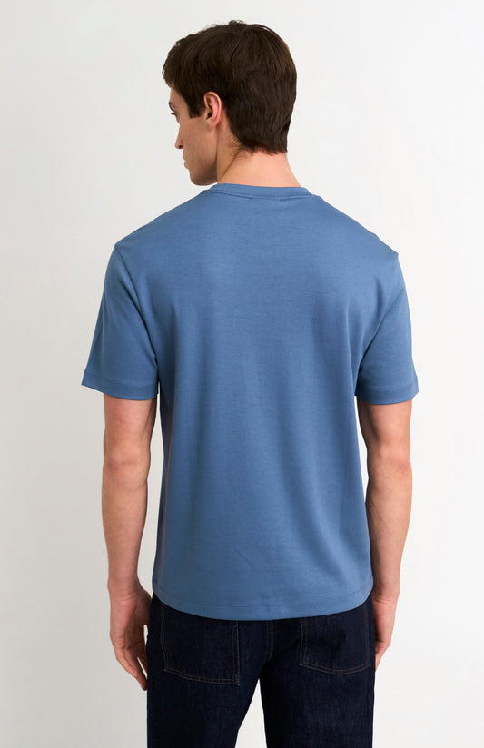 Man wearing a blue t-shirt and jeans on a white background