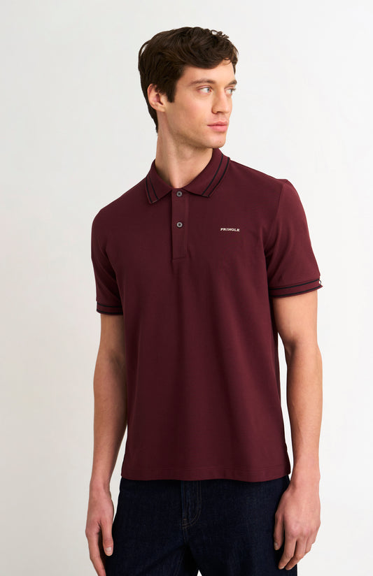 Model wearing a burgundy polo shirt with black tipping details