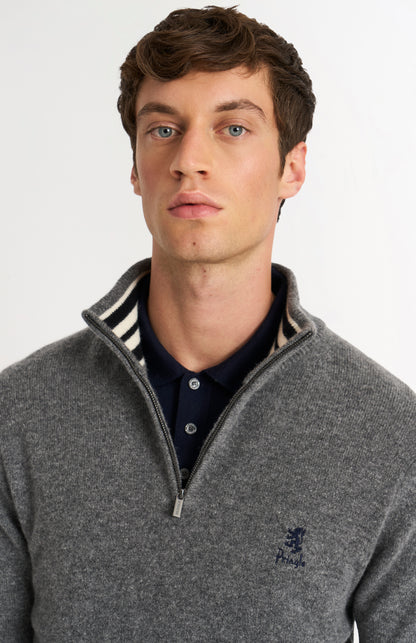 Man wearing a gray sweater with a zipper and a Pringle logo on a light gray background