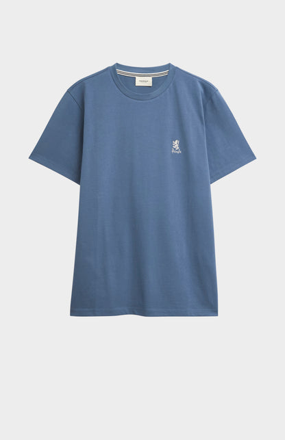 Blue t-shirt with a small logo on a light gray background