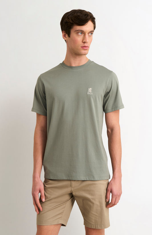 Man wearing a green t-shirt with a logo on a white background