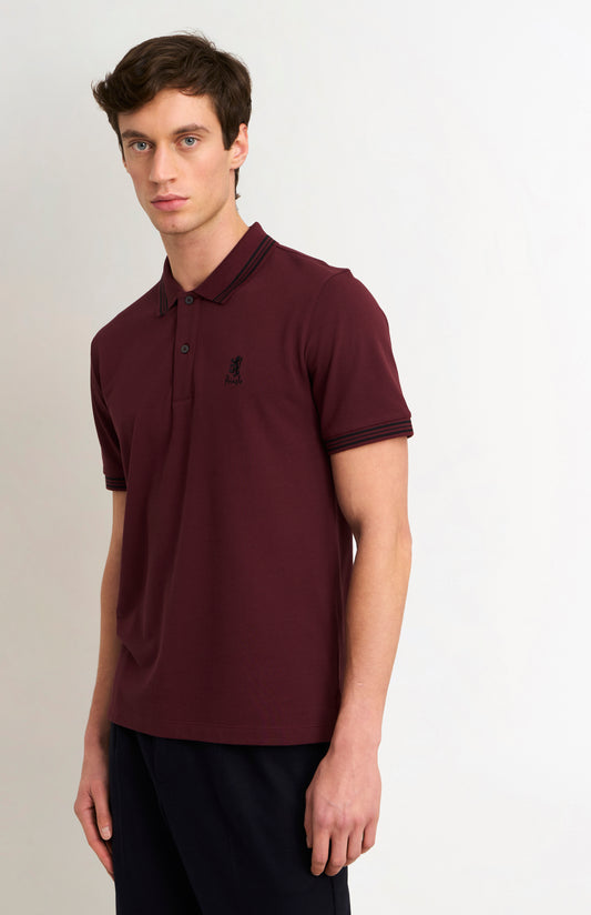 Model wearing a burgundy polo with black tipping and a small Pringle logo on top side of chest