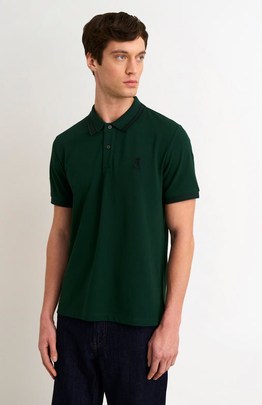 Model wearing a forest green polo with tipping details and small Pringle logo on upper side of chest