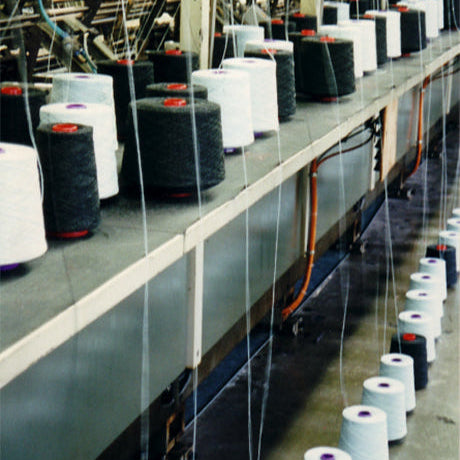 Pringle knitting factory with spools of thread on a knitting frame.